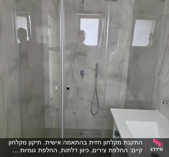 מקלחון זכוכית עם ראש מקלחת וכיור לבן